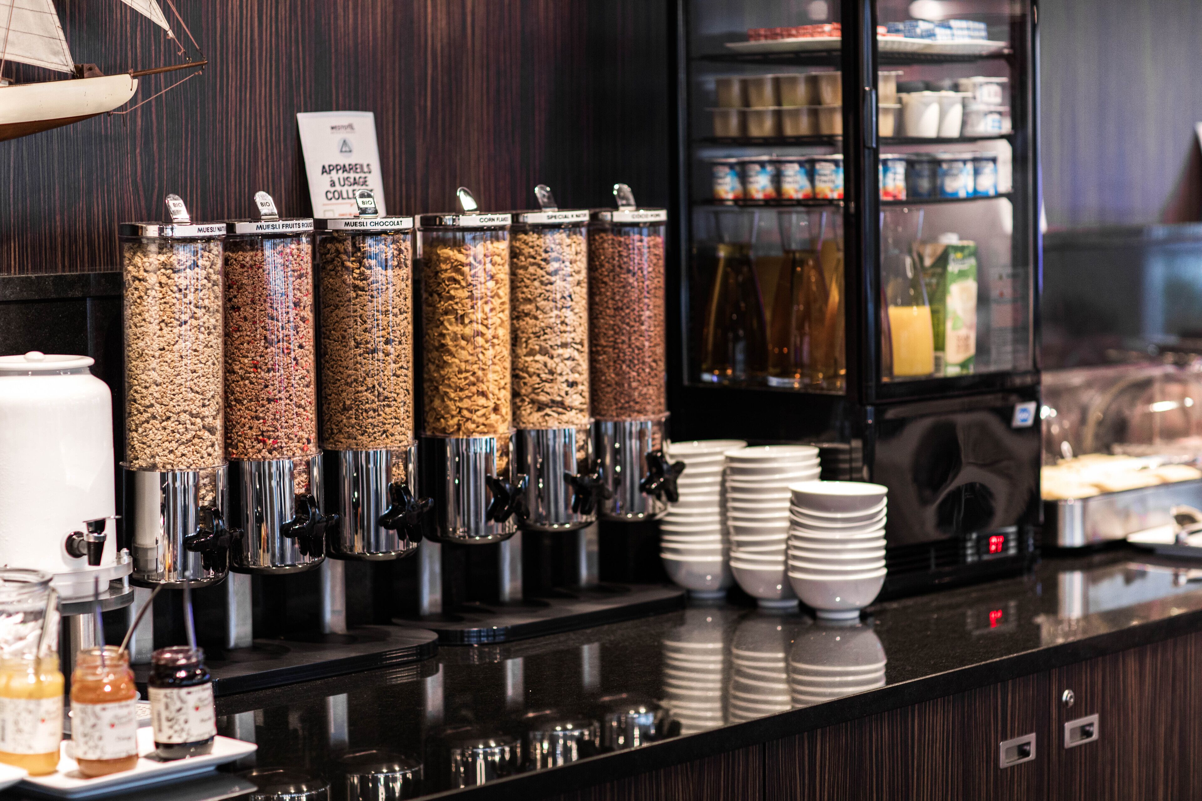 Een koffiehoek met zelfbediening, met diverse dispensers voor koffie, thee en melk.