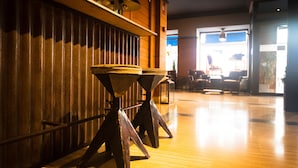 A wooden floor with a metal railing and a table with a round top. - Hostal Persal (Madrid)