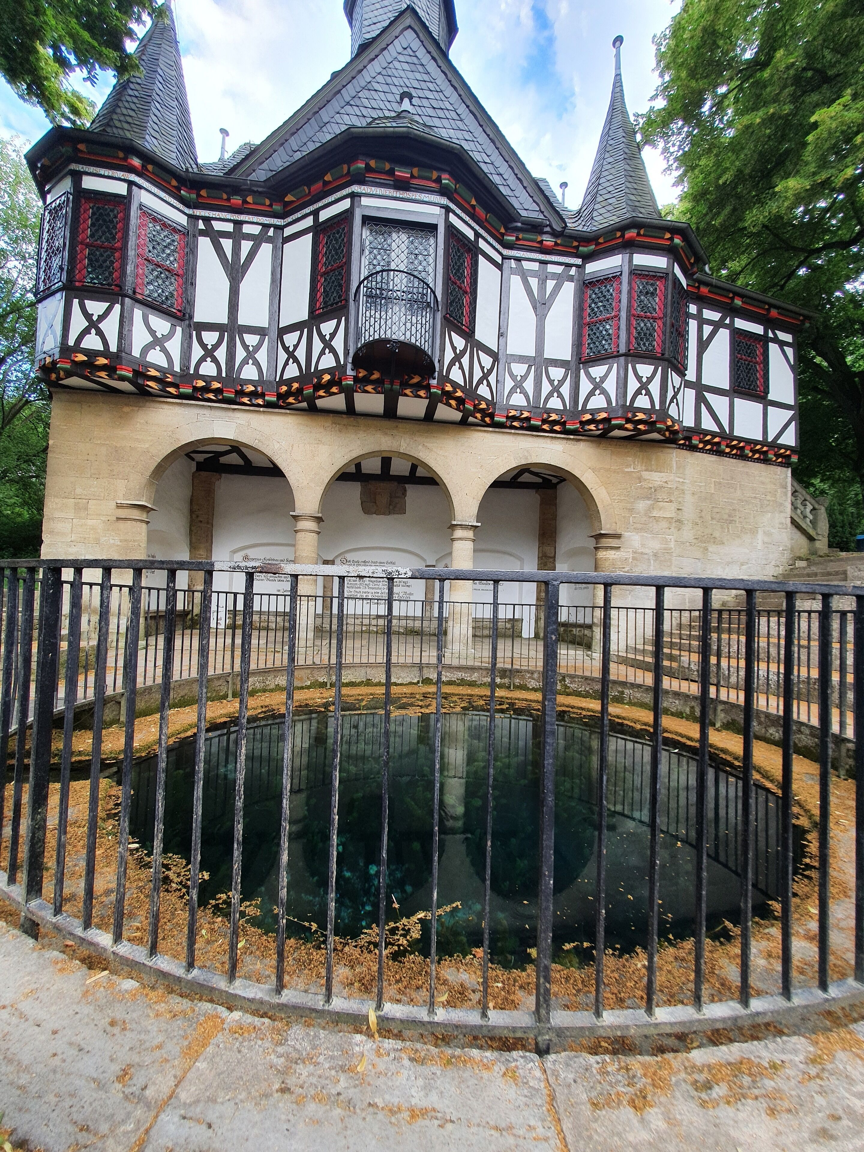 A historic building with a central courtyard and a reflective water feature.