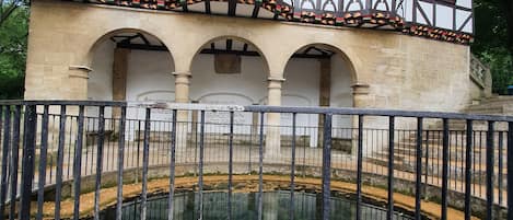 A historic building with a central courtyard and a reflective water feature.
