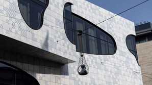 Facciata di un edificio con decorazioni in piastrelle a motivi, ampie finestre e un lampadario.