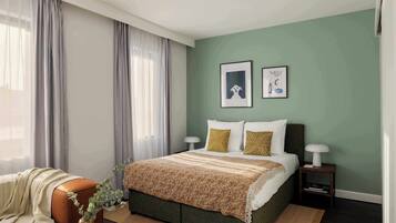 Un dormitorio con cama, cortinas, mesita de noche y decoración en la pared.
