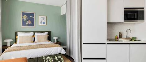 Un dormitorio con cama, mesitas de noche y una mesilla.