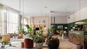 Un'ampia hall con posti a sedere, piante in vaso e una reception.