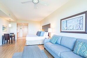 Une chambre d’hôtel avec un lit, un canapé, une table à manger et un ventilateur de plafond.
