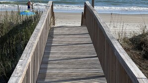 A wooden boardwalk leading to a beach with a sign reading "DUNEDIE DR". - Luxury Waterfront Paradise at Ocean Isle Beach: Enjoy the Beach and Jink's Creek (Ocean Isle Beach)