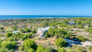 An aerial view of a residential area with houses, a swimming pool, and a clear view of the sea. - Superb villa with pool and 180° sea view (Torre Pali)