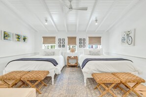 A bedroom with two beds, a ceiling fan, and framed pictures on the walls. - WaterColor "Wine Down" | Sleeps 6 | 6 Seater Golf Cart |Walk to Beach | Bikes (Santa Rosa Beach)