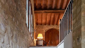 A staircase with stone walls and wooden beams, leading to a room with a wooden door and a lamp. - HAMLET THE POET - HOUSE SANTA LUCIA (Umbria)