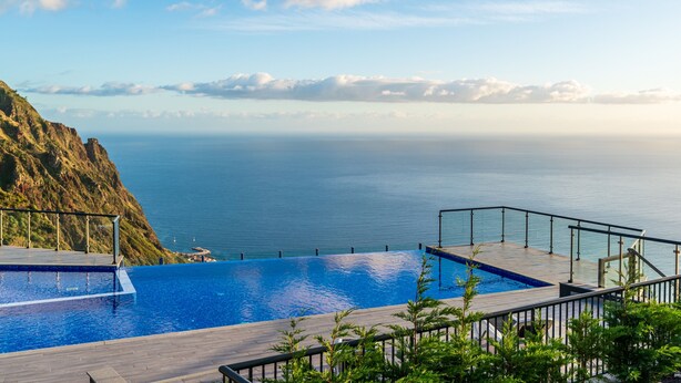 A pool with a view of the ocean and a rocky cliff. - Modern villa, shared infinity pool | SunsetCliff 7 (Faja Da Ovelha)