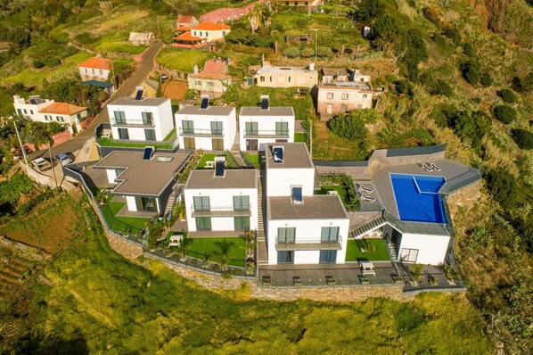 A modern residential complex with multiple two-story buildings, a swimming pool, and a well-maintained garden.