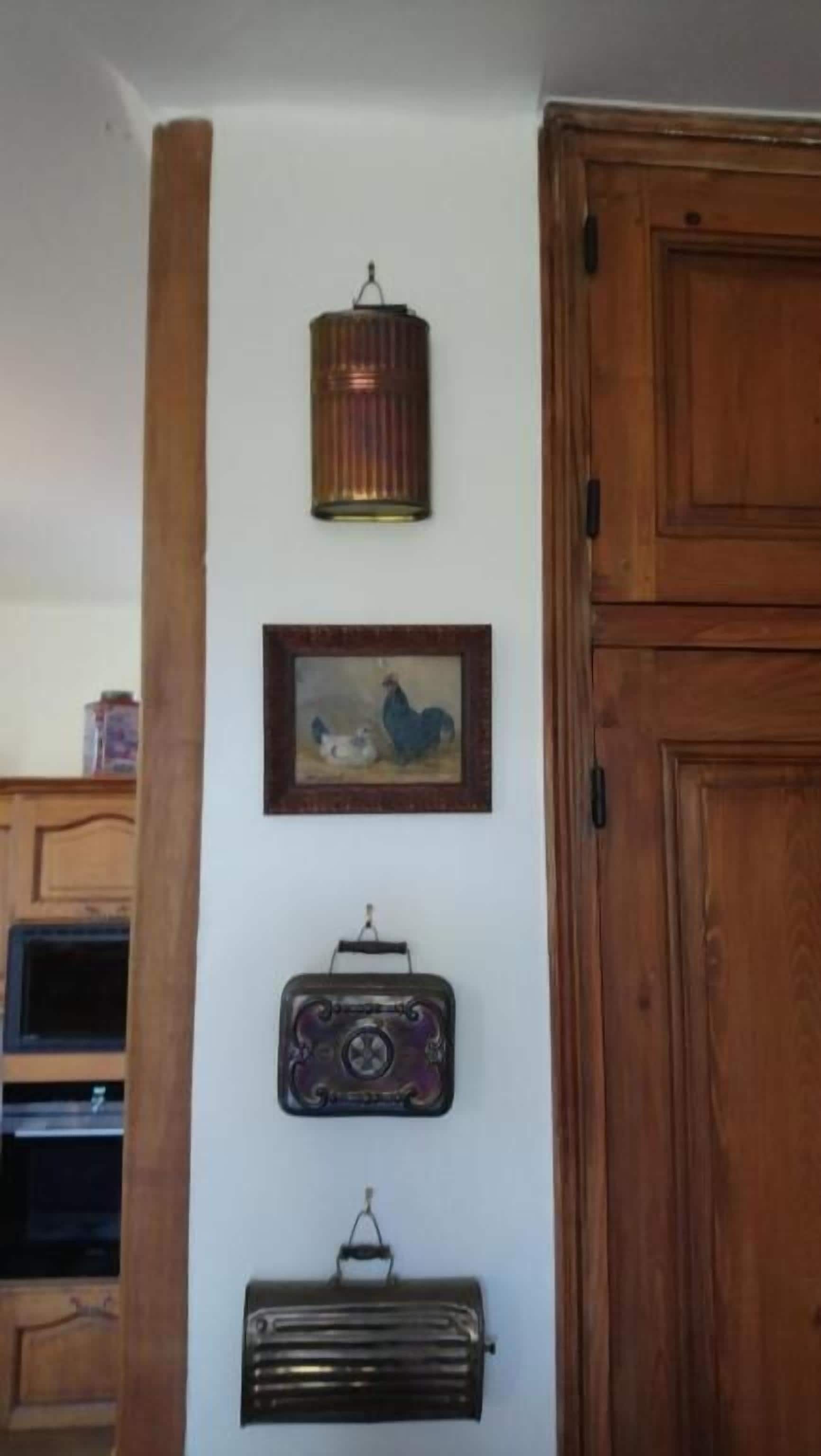 A wall with a vintage radio, a framed picture, and a hanging lantern.
