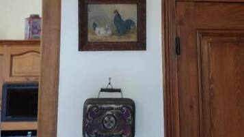 A wall with a vintage radio, a framed picture, and a hanging lantern.
