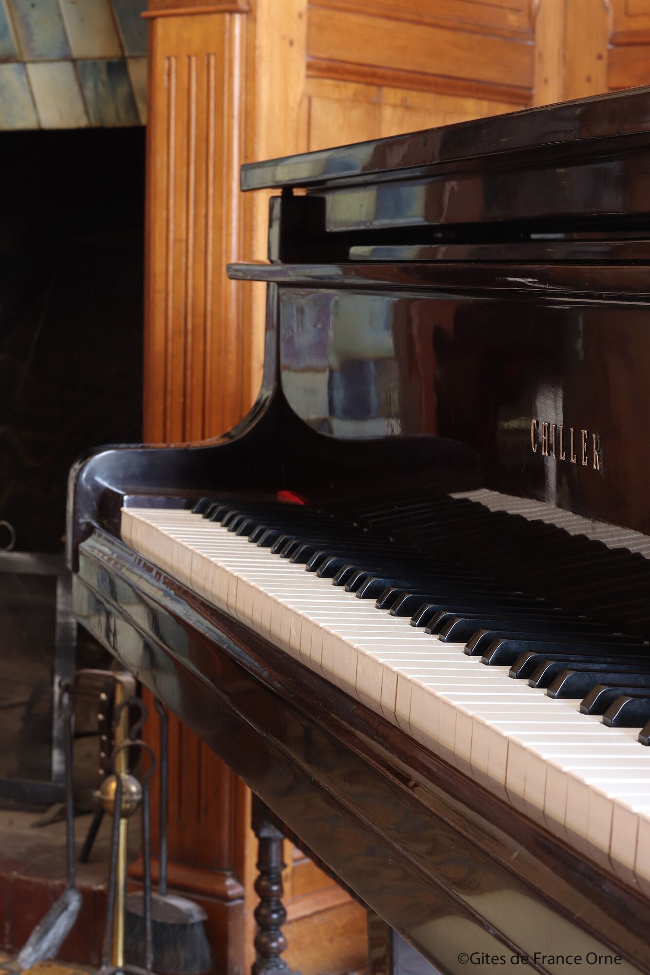 A grand piano with a glossy black finish and the brand name "CHILLER" visible on the side.