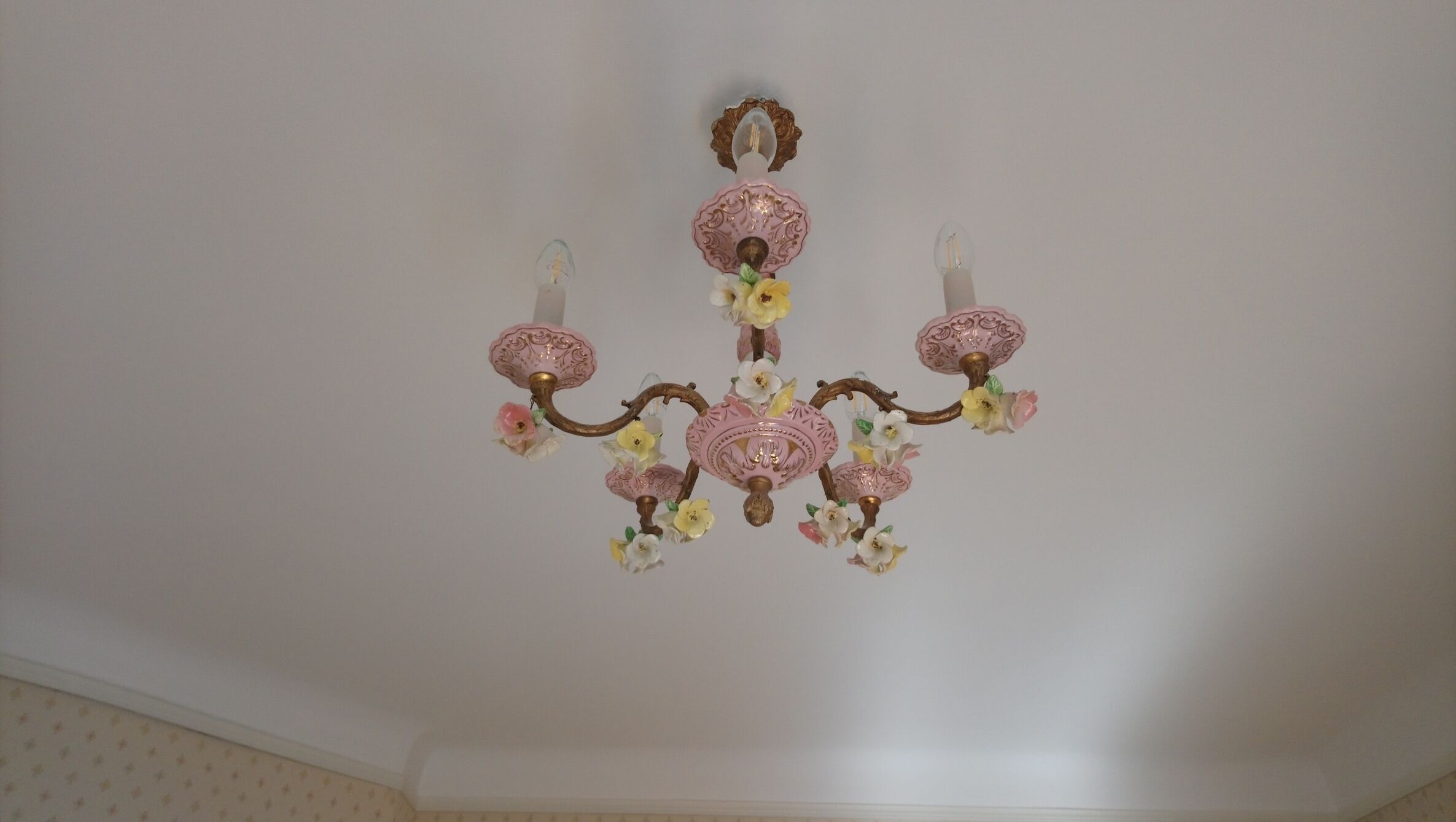 Un lustre à plusieurs bras, orné de motifs floraux.