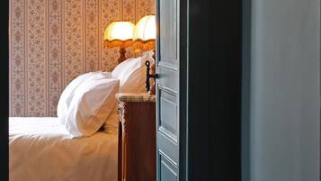 Un dormitorio con una cama, una mesita de noche con una lámpara y un cuadro enmarcado en la pared.