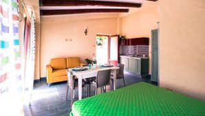 Une pièce confortable comprenant un lit, une table à manger avec des chaises, un canapé et un coin cuisine.