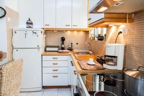 Enjoy cooking in this well-equipped kitchen with a coffee maker, kettle, and sink.