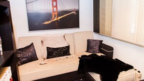 A room with a sofa, a framed picture of the Golden Gate Bridge, and a patterned curtain. - Amazing apartment with view (Piraeus)