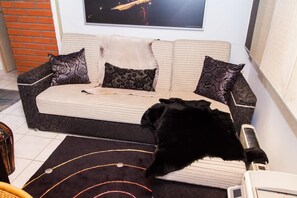 Relax in this inviting living area with a sofa, TV, and cozy rug.