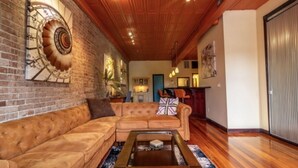 A living room with a wooden ceiling, a brick wall, and a sofa. - Contemporary apartment on the square! (Neosho)