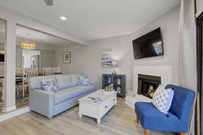 A living room with a sofa, coffee table, and fireplace.