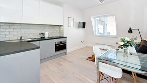 Een moderne keuken met witte kasten, een zwart aanrecht en een ingebouwde oven.