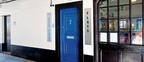 Un bâtiment avec une porte bleue portant le numéro « 7 » et une enseigne au-dessus indiquant « Manette Street W1, ville de Westminster ».