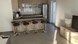 A modern kitchen with a central island, stainless steel appliances, and a bar stool seating area. - Villa Pina Tisno TOP**** Apartment Luca 4-6 Persons (Tisno)