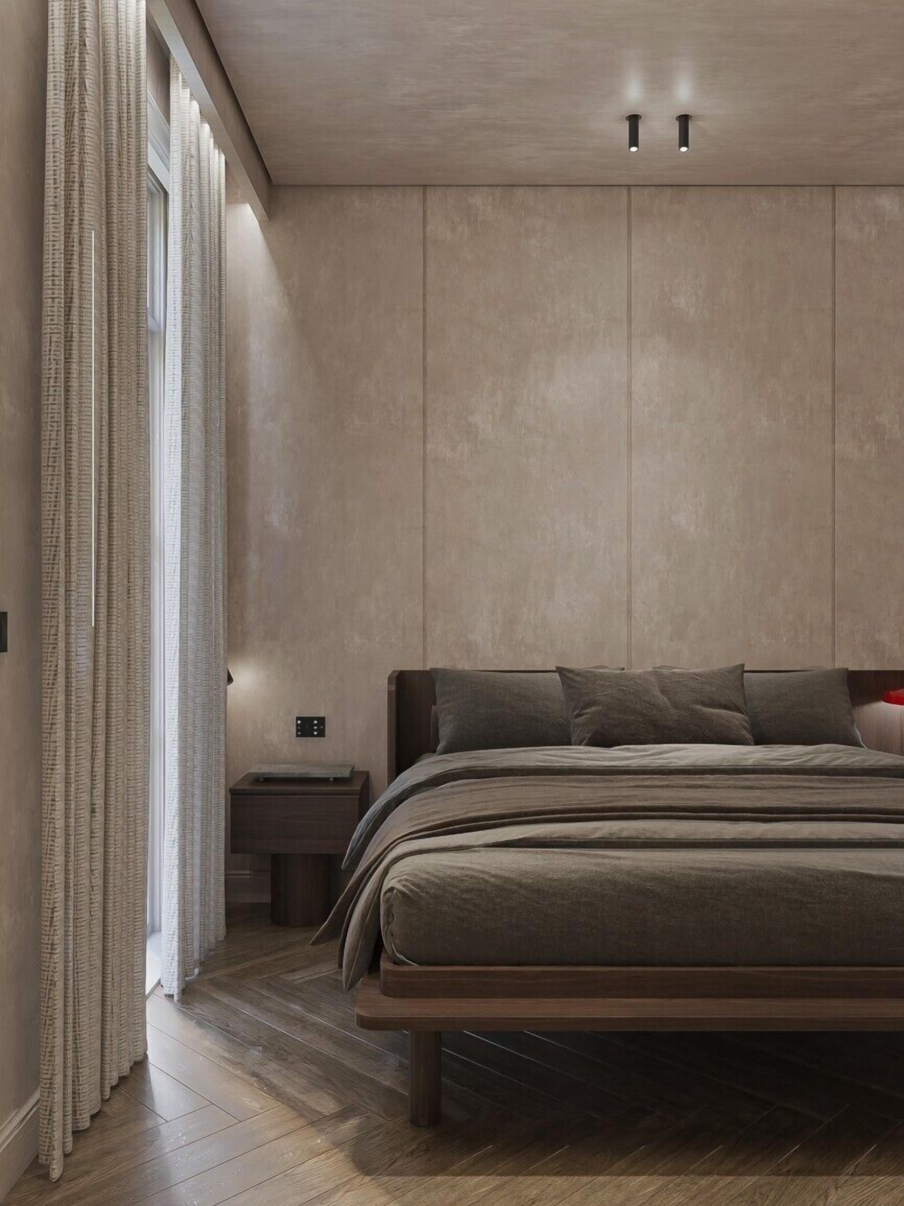 A modern bedroom with a bed, bedside table, and a window with curtains.