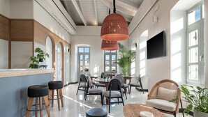 Un interior moderno con una zona de bar, asientos y ventanas amplias.