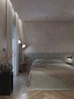 Un dormitorio moderno con una cama grande, una mesita de noche, una lámpara de pie y un florero con flores.