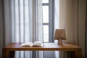 Ένα ξύλινο τραπέζι με ένα ανοιχτό βιβλίο και μια λάμπα.