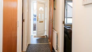 A hallway with a wooden door, a white door, and a radiator. - 10 Annesley Park (Banchory)