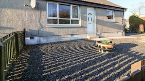 A two-story house with a tiled roof, a white door, and a satellite dish. - 10 Annesley Park (Banchory)