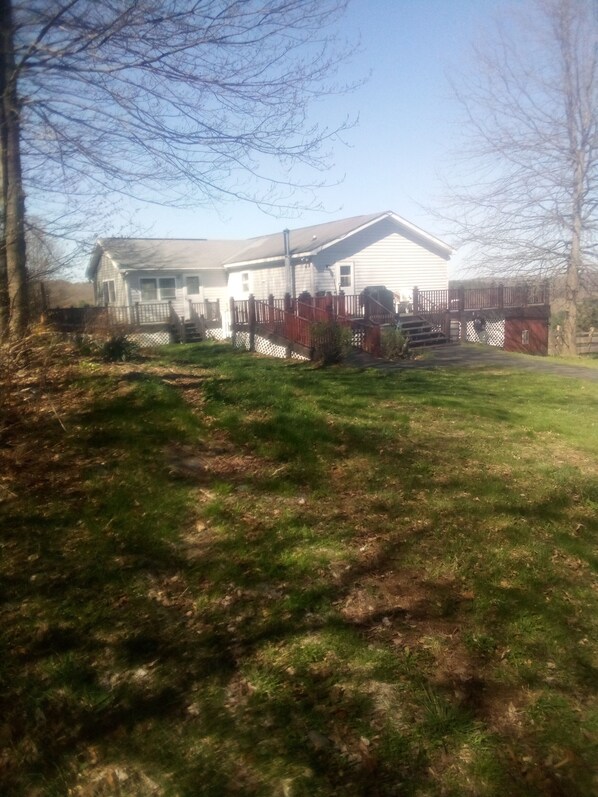 A house with a front porch, a fenced yard, and a driveway leading to the garage.