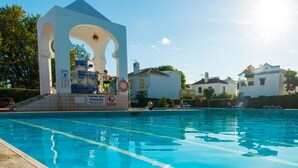 Una piscina con una estructura blanca y un puesto de socorristas.