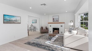 A modern living room with a fireplace, a sofa, a coffee table, and a rug. - Newly Updated!  RiverView Retreat  Historic Fort Myers, FL 10 guests, Spa & pool (Fort Myers)