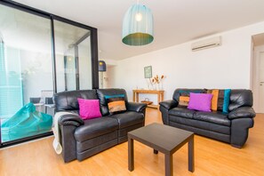 Ein modernes Wohnzimmer mit Ledersofas, einem Couchtisch und einem großen Fenster.
