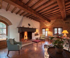 A rustic interior with a fireplace, wooden beams, and traditional furniture.
