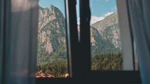 A window view of a mountainous landscape with a clear sky. - Suru Hotel & Restaurant (Busteni)