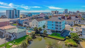Uma área residencial costeira com edifícios altos, um porto de iates e vista clara para o oceano.