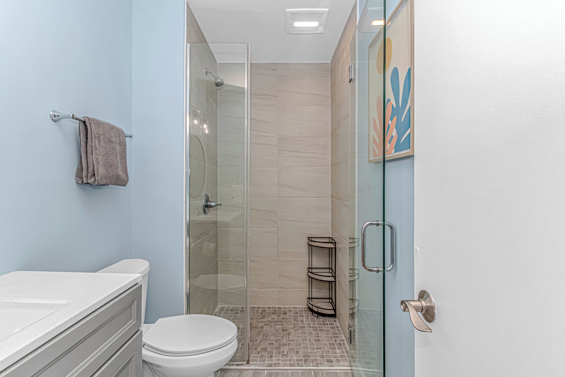 Une salle de bain avec des toilettes, un lavabo et une douche.