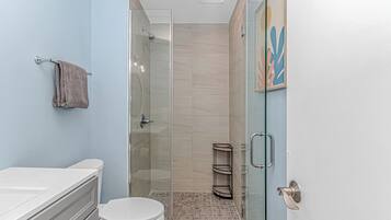 Une salle de bain avec des toilettes, un lavabo et une douche.