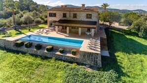 A two-story stone house with a swimming pool, outdoor seating, and a view of the surrounding landscape. - Esturonet, Finca 5EstrellasHome Mallorca (Manacor)