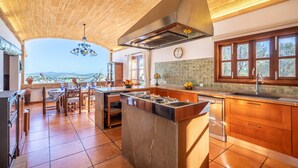 A spacious kitchen with a large island, wooden cabinets, and a view of the countryside. - Esturonet, Finca 5EstrellasHome Mallorca (Manacor)