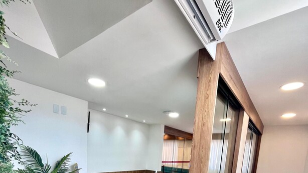 A reception area with a wooden reception desk, potted plants, and a staircase leading to an upper floor. - Pousada Mirante dos Corais (Ipojuca)