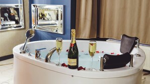 A bathtub with champagne, glasses, and rose petals. - Mas Suites Karaköy (Istanbul)