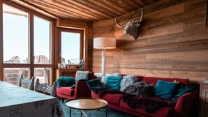 A wooden interior with a red sofa, a table, and a lamp. - Immodreams - Le Lodge - Avoriaz (Avoriaz)