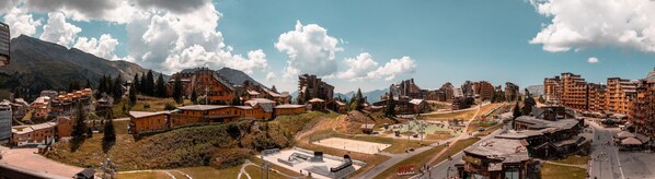 A mountainous town with traditional wooden buildings, a ski slope, and a train station.